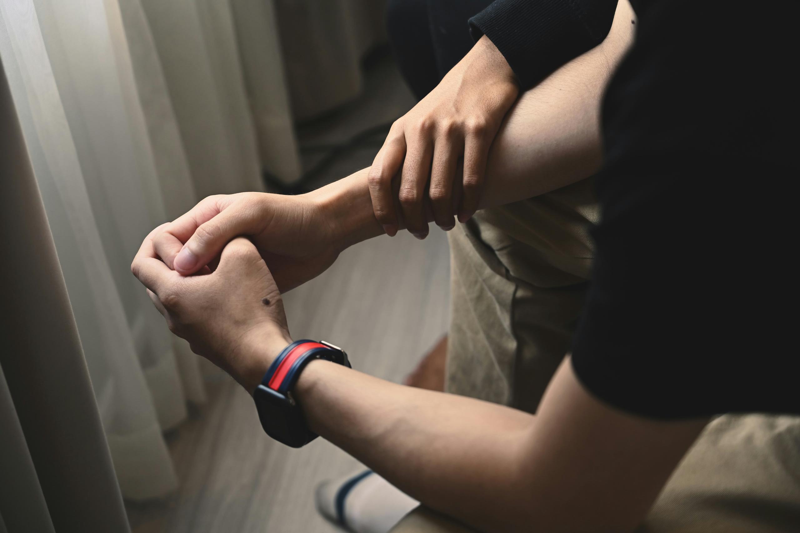 a person holding the arm of another person in support