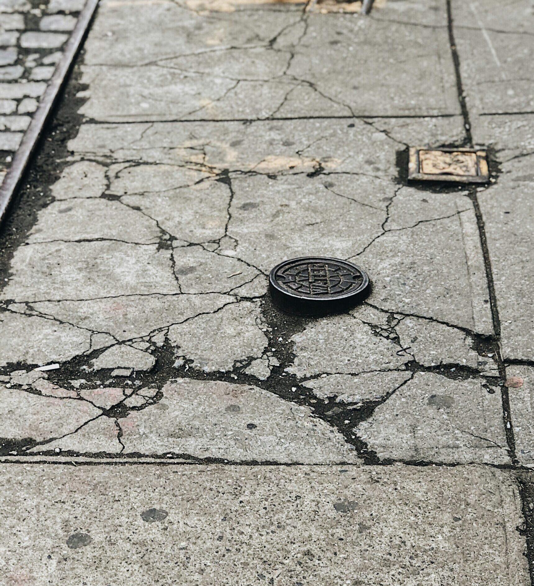 woman in black heeled sandals walking on gray concrete pavement