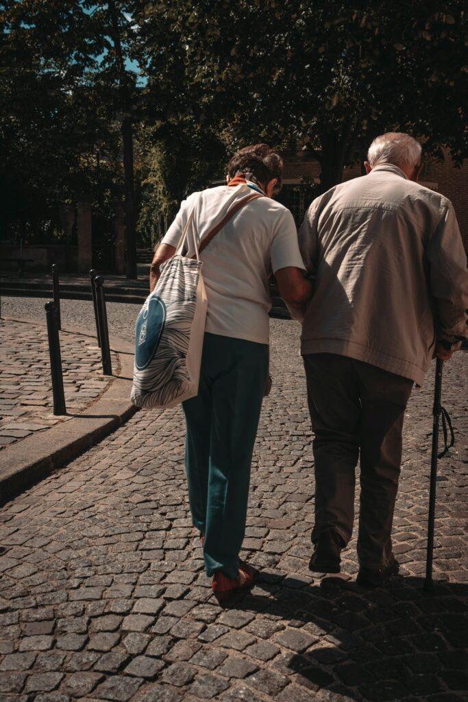 man in brown shirt and blue denim jeans standing beside woman in white long sleeve shirt