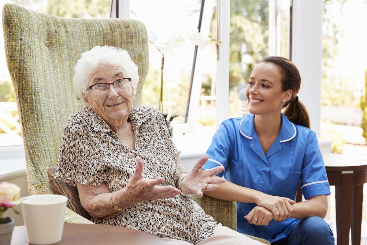 Elderly woman with aide in an assisted living facility