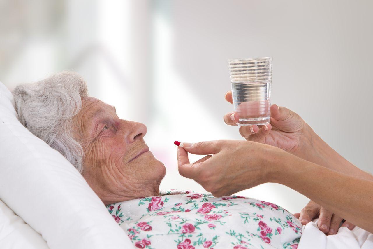 Elderly woman nursing home patient being given medication