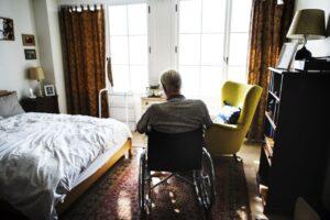 Lonely man sitting in a wheelchair in a nursing home