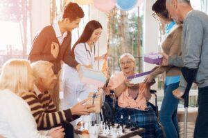 Family members visit grandma at a nursing home to celebrate her birthday