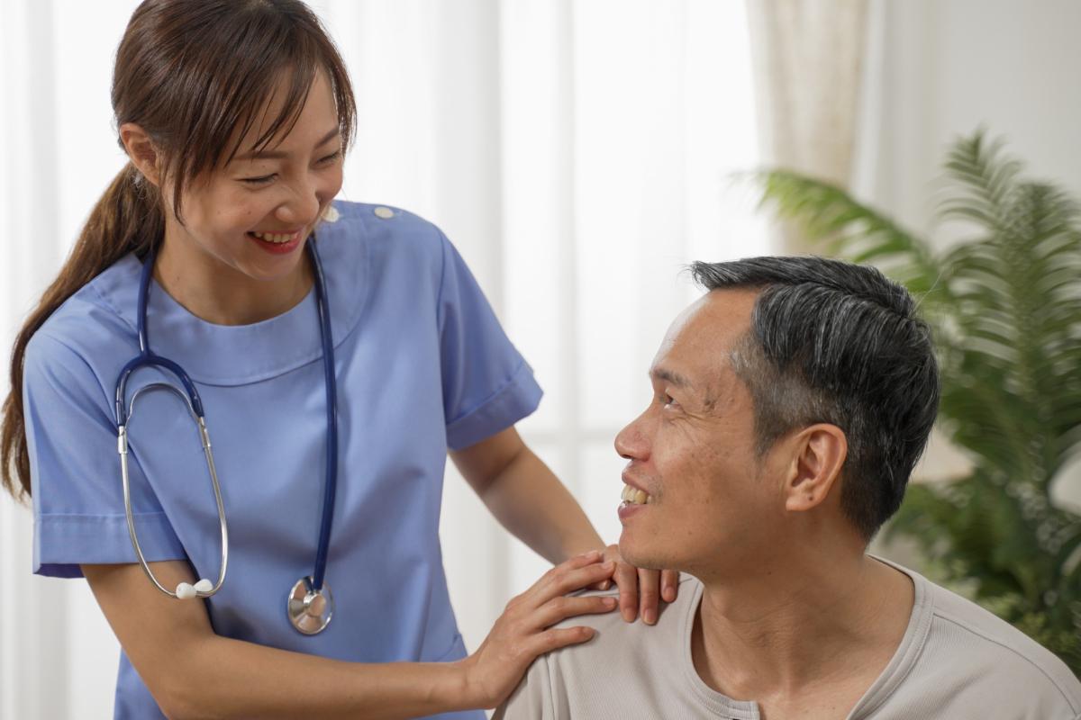 Nurse speaking with elderly resident. Nursing home vs assisted living facility.