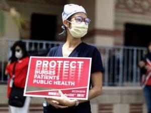 Frontline healthcare worker holding a protest sign