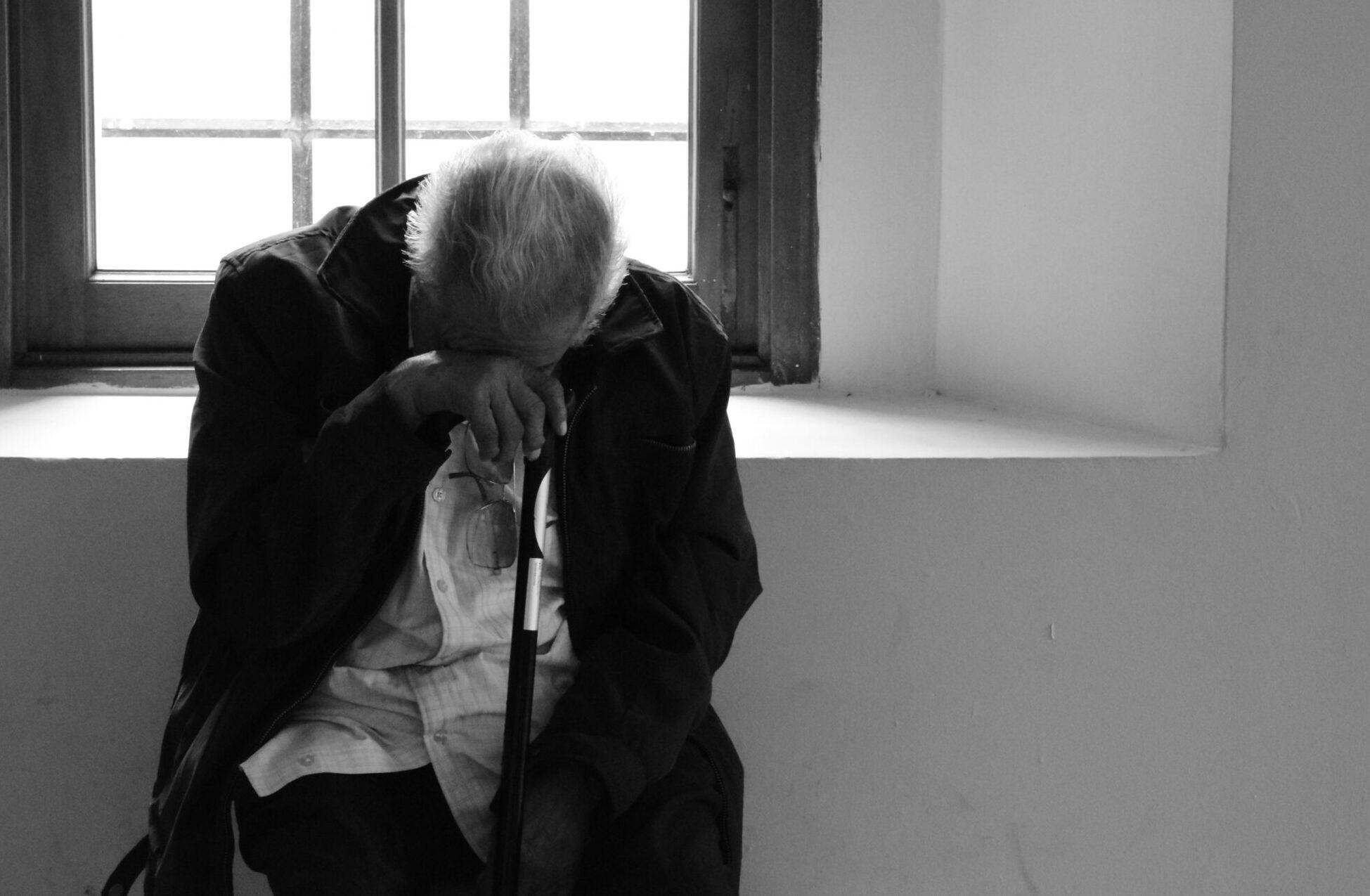 man sits on chair near window
