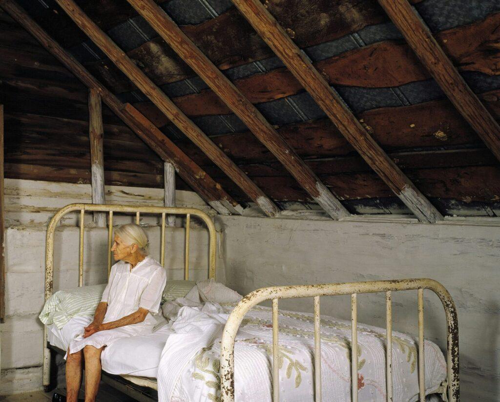 elderly woman sitting on a bed