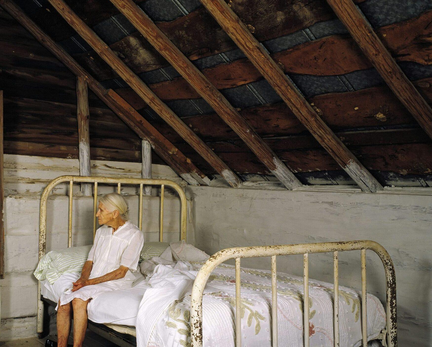 elderly woman sitting on a bed