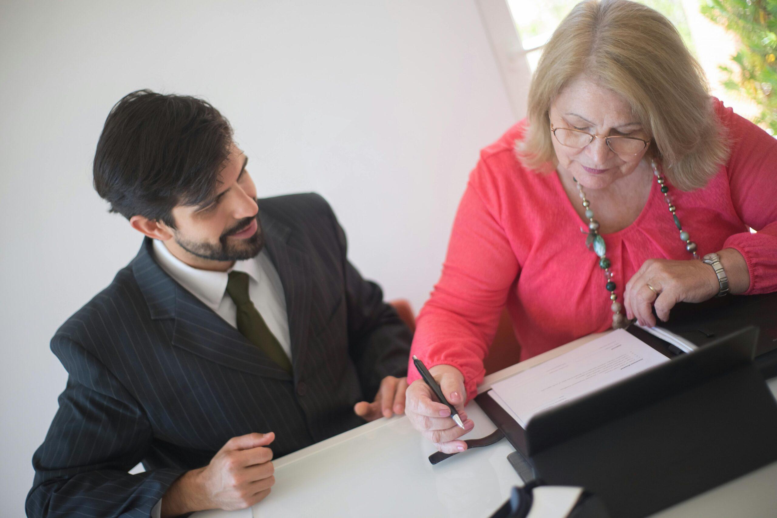 woman listening to a lawyer discuss a nursing home's forced arbitration document
