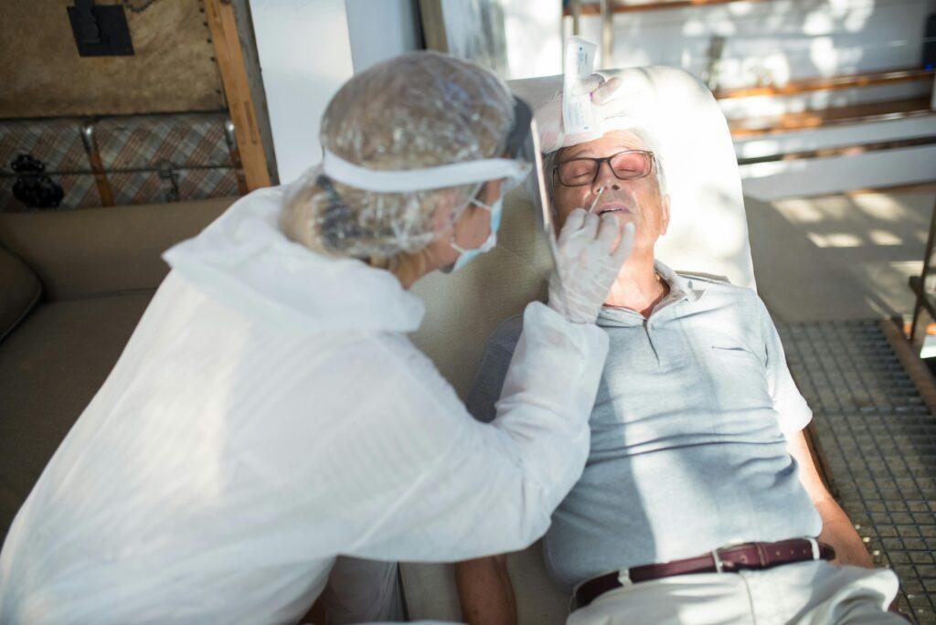 elderly man having his COVID-19 test taken